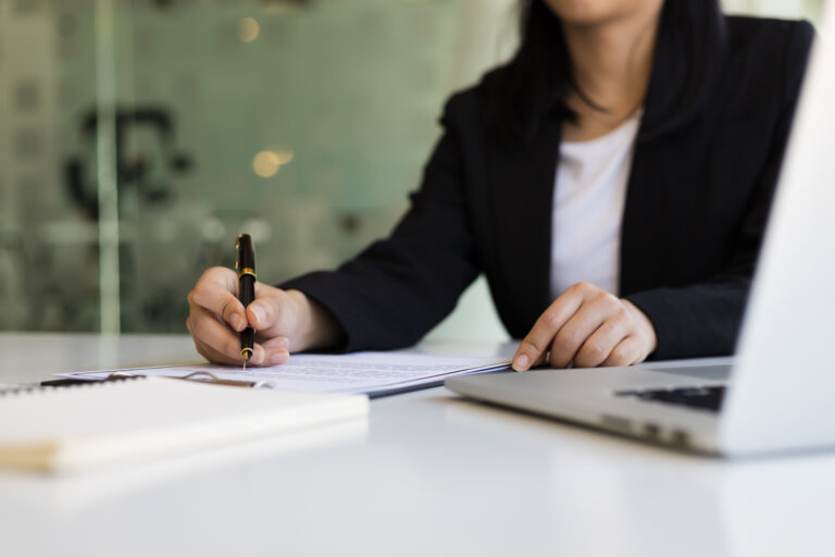 Business woman holding a pen to signing a document contract business agreement. legal hammes law